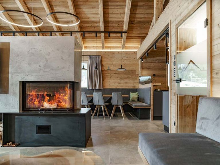 Winterurlaub im Chalet bedeutet Luxus Pur! Gemütliches Wohnzimmer mit einem brennenden Kamin