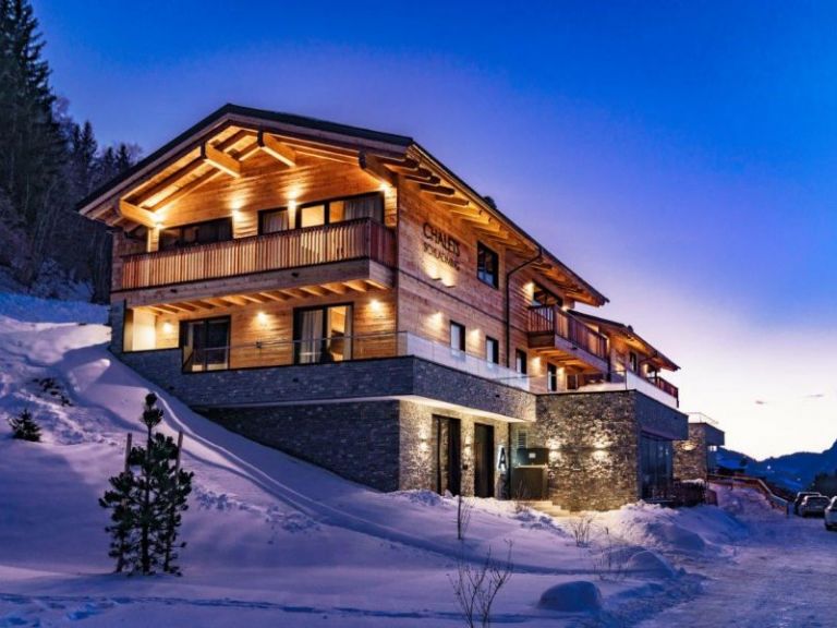 Ein beleuchtetes Chalet in der Abenddämmerung